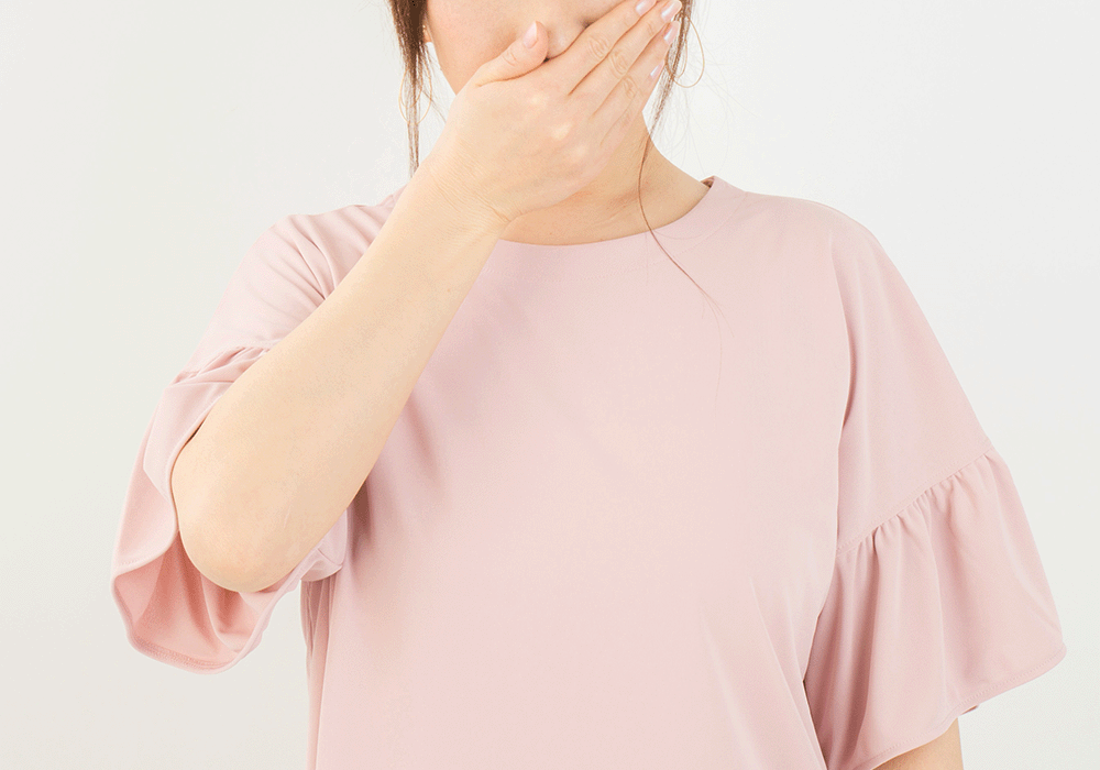 口を押える女性